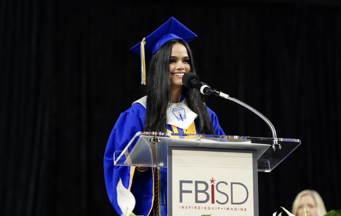 Varshni speaking at graduation in cap and gown